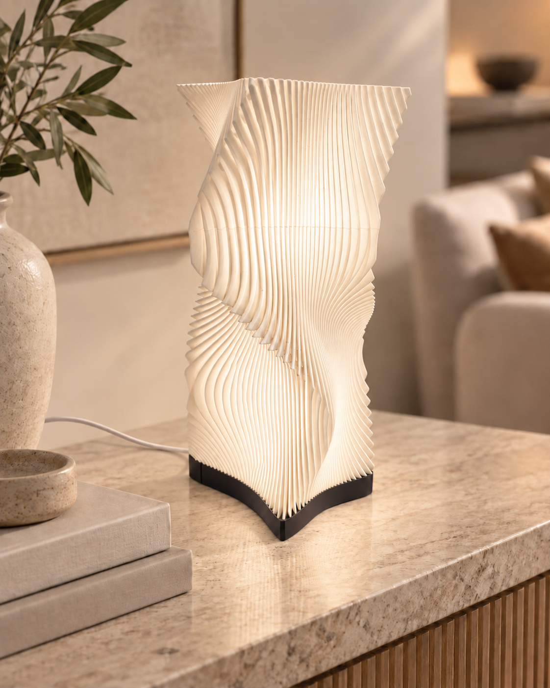 Vela sculptural table lamp softly illuminated in a warm modern interior